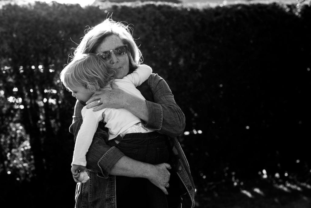 Grandmother hugging granddaughter in backyard session