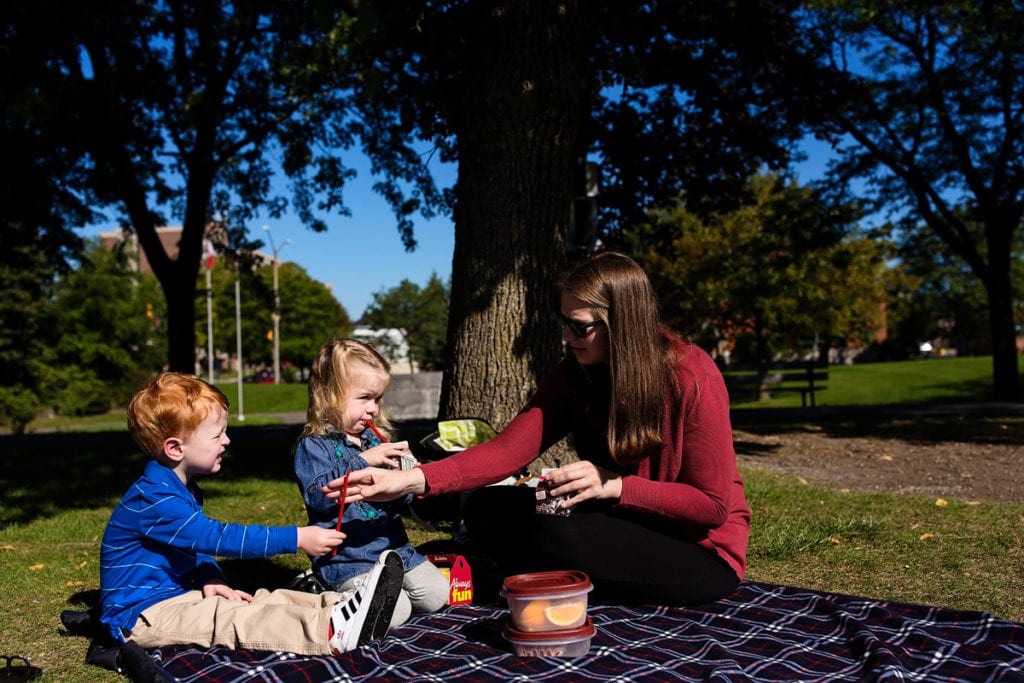 mom with kids having sunny summer picnic in Cornwall park family session