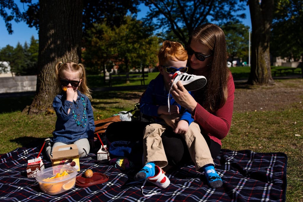 mom with son and daughter having picnic lunch in the park