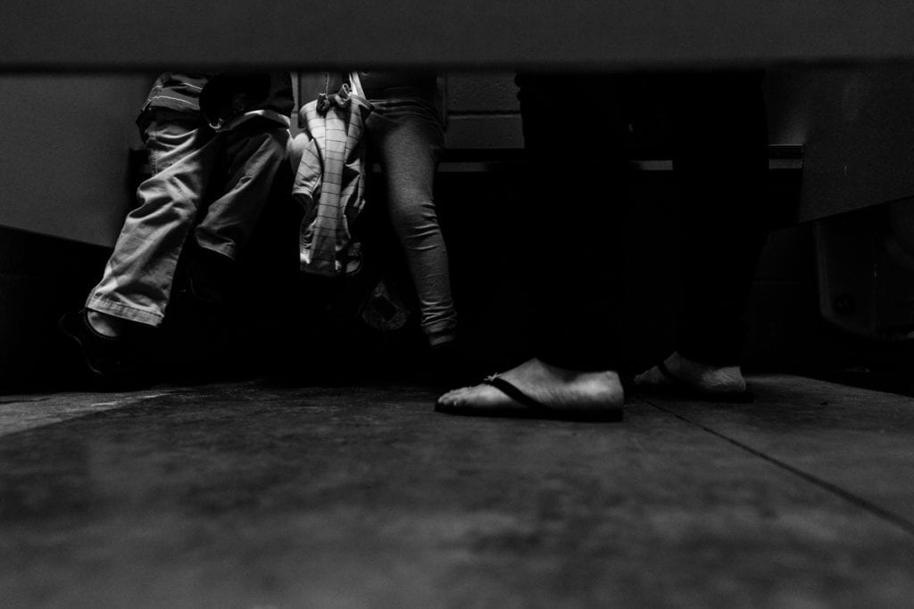 mom and kids' feet peeking out from under door
