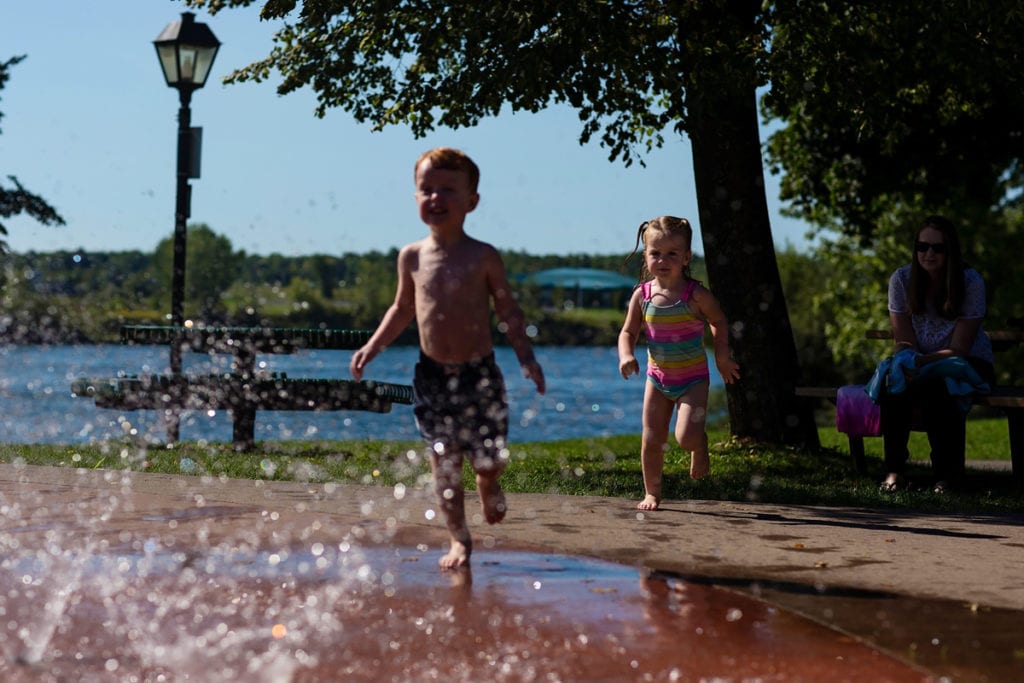 little boy and sister running and playing in Cornwall outdoor splash pad