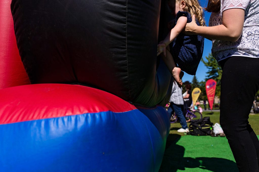mom putting little girl into bouncy castle