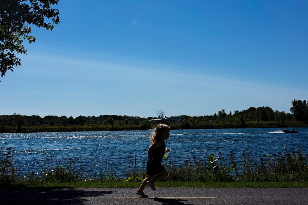 little girl running down path beside St Lawrence River