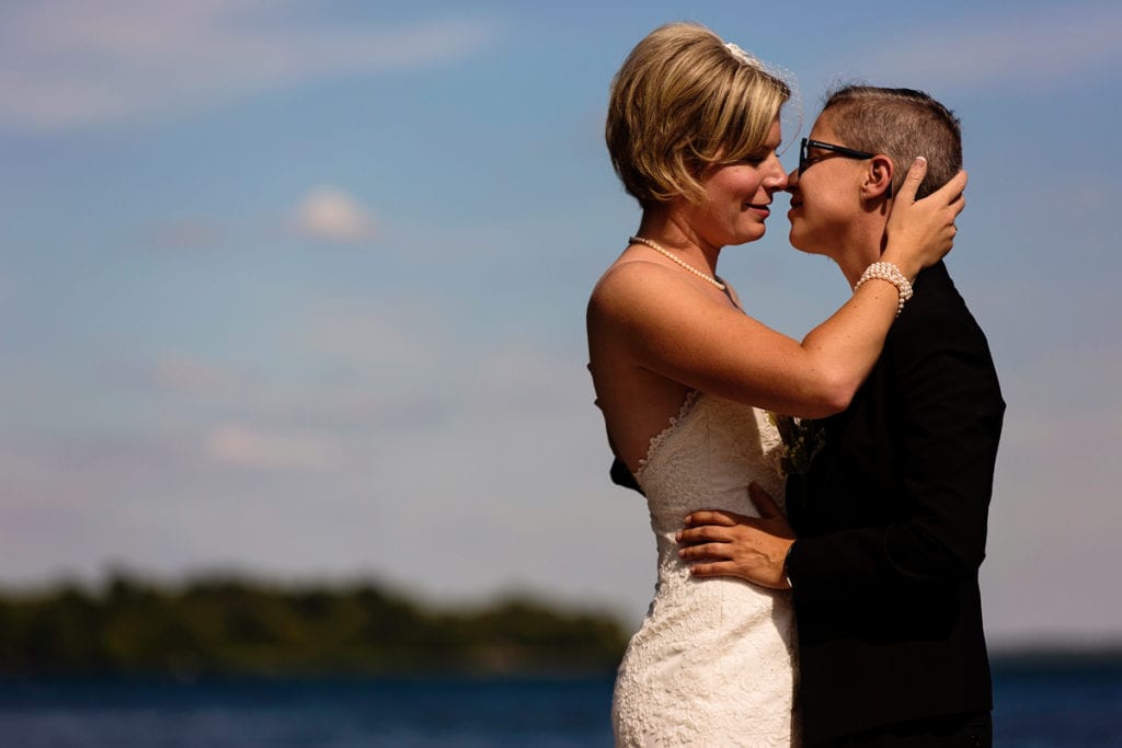 same-sex brides kissing in waterfront wedding shot
