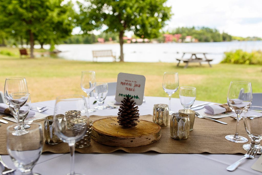 burlap rustic cut wood and pine cone centerpiece at lakeside wedding