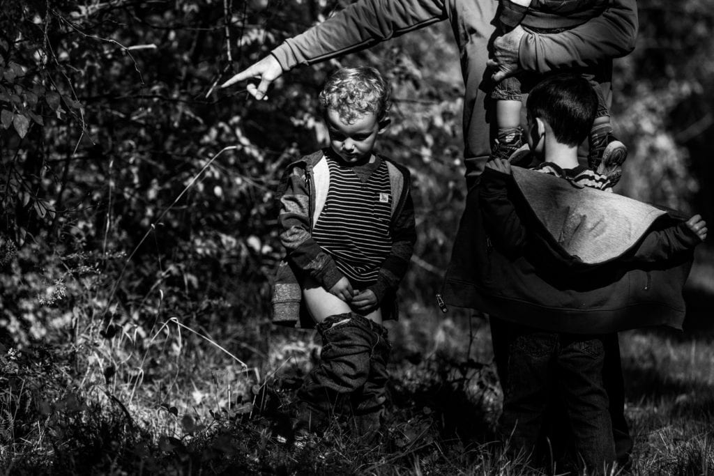 little boy taking a pee in the forest