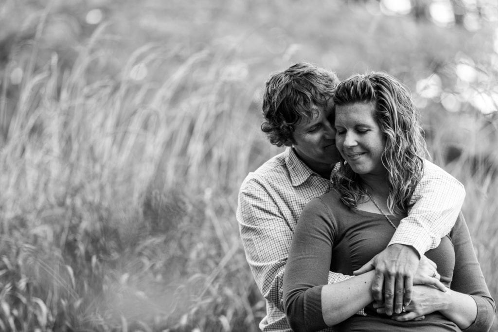 couple cuddling in tall grass in rural Martintown engagement session