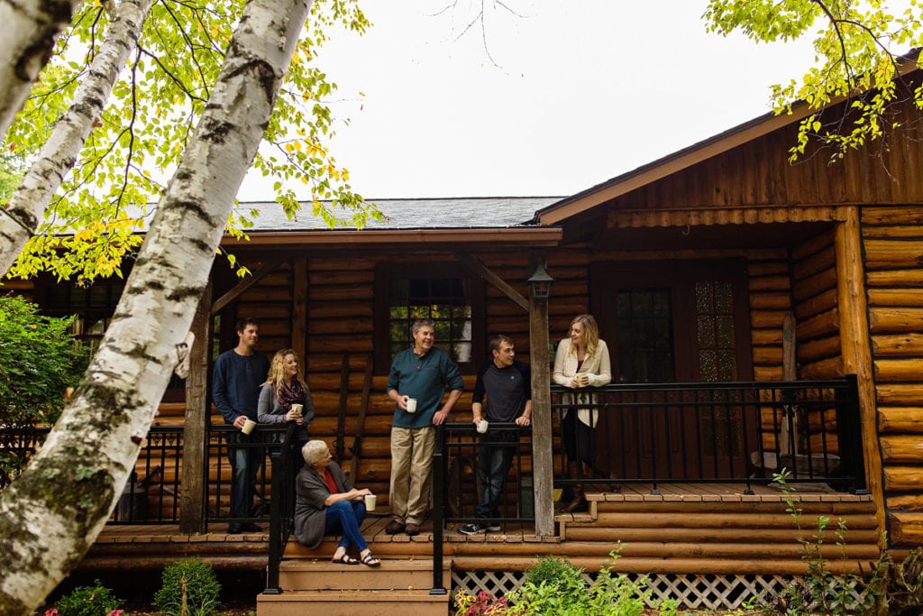 family sharing coffee and time on deck of log cabin during Ontario Casual Family Portraits