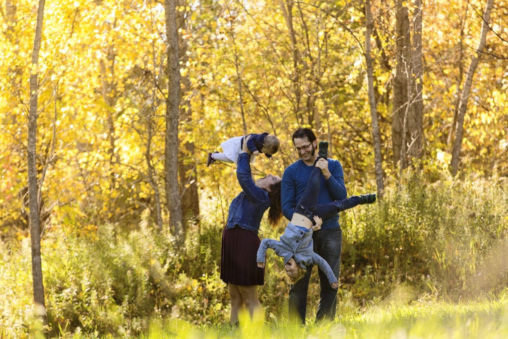 parents laughing and playing with two young children in Candid Cornwall Family Portrait