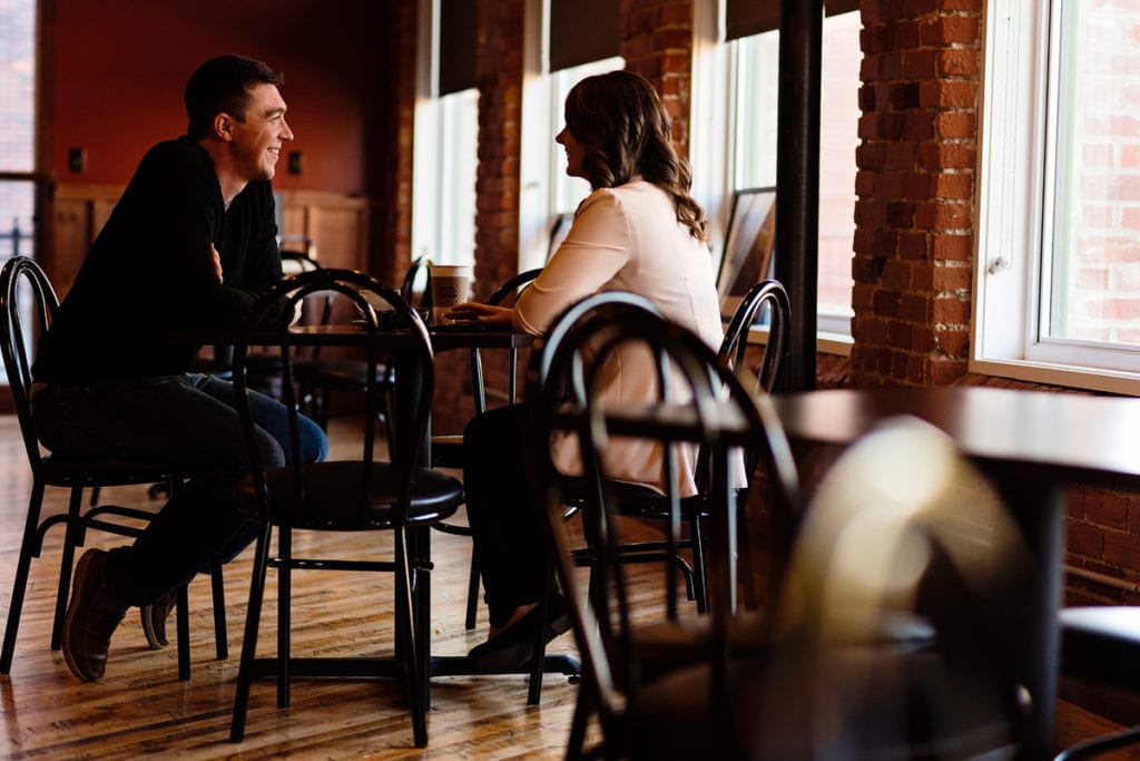couple in sunlit coffee shop in fall Cornwall engagement session