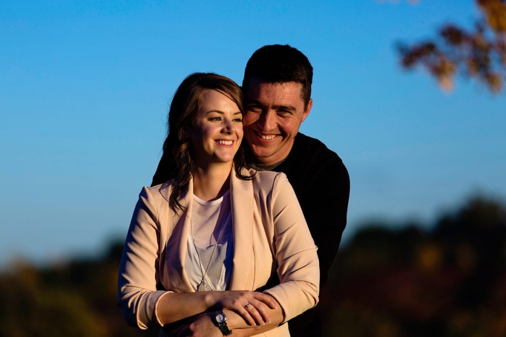 couple smiling and laughing in sunset fall engagement session