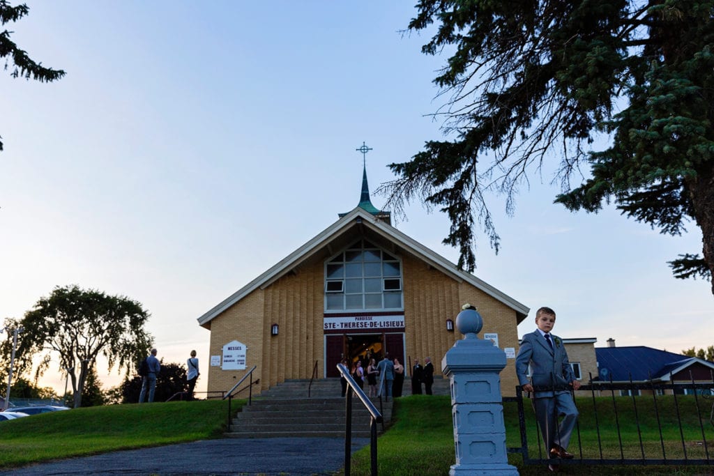 ring bearer waits for bride to arrive for Cornwall evening wedding