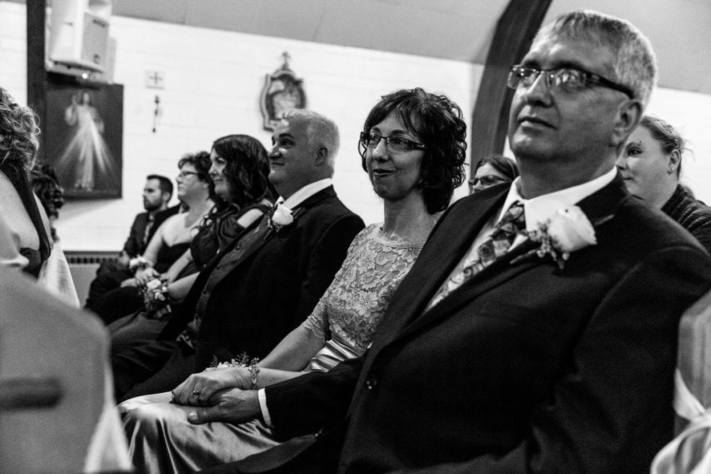 mother and father watch daughter get married during Cornwall evening wedding