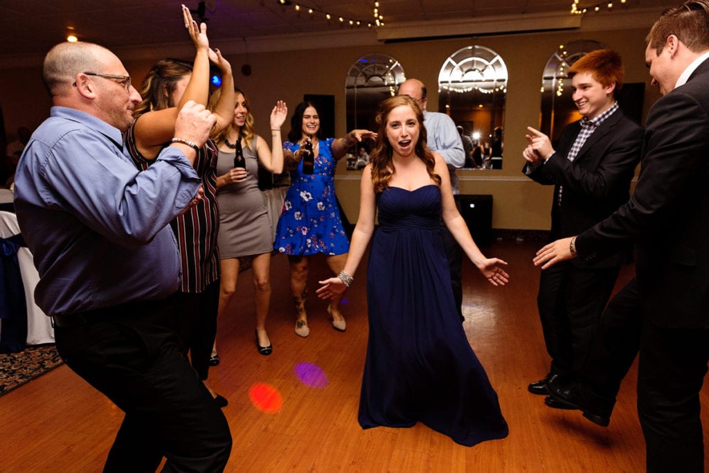 girl dances in centre of circle during Cornwall evening wedding