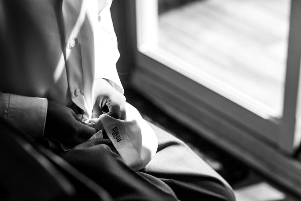 ring bearer does up buttons on dress shirt