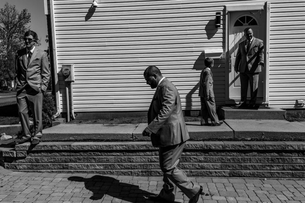 groomsmen leave house to prepare for Cornwall evening wedding