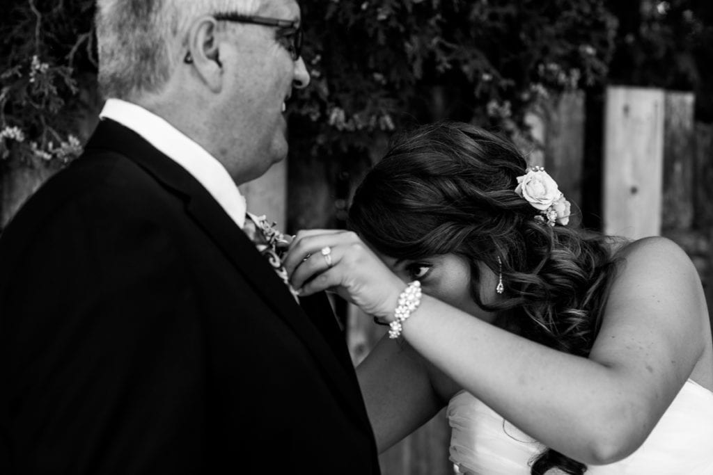 Cornwall bride attaches boutonniere to father's lapel