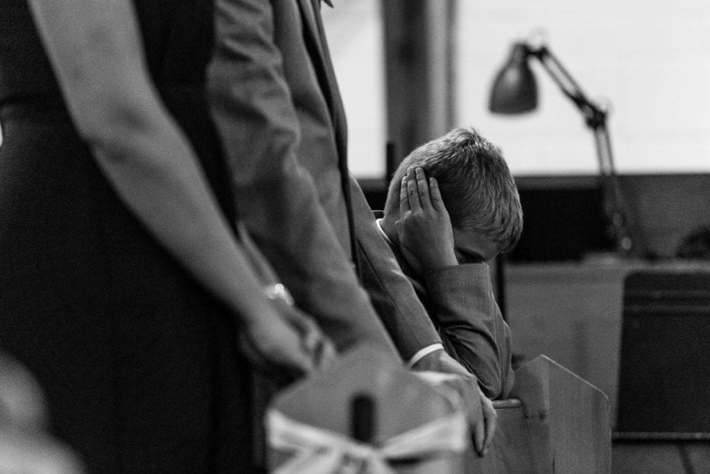 Boy blocks ears during Cornwall evening wedding
