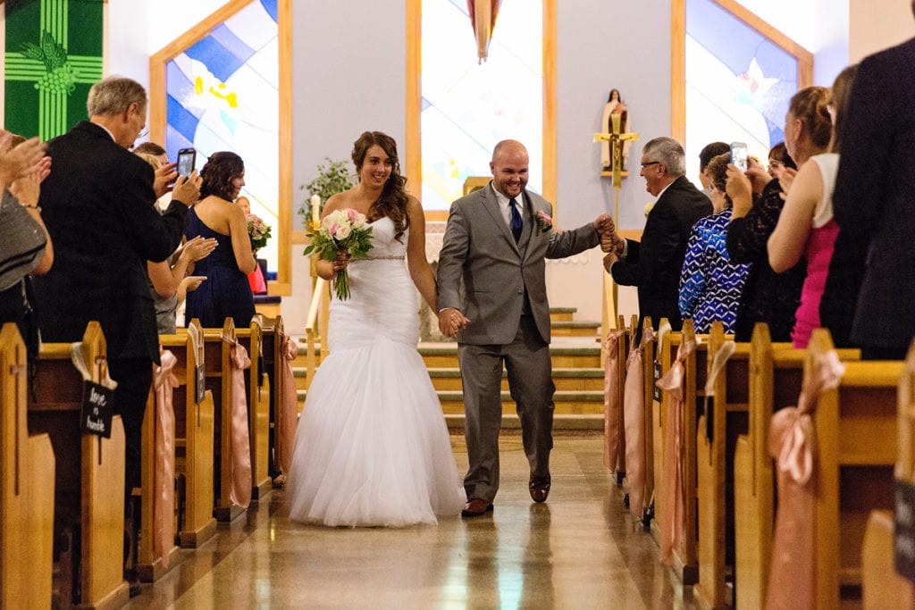 Bride and groom exit down aisle after their Cornwall evening wedding