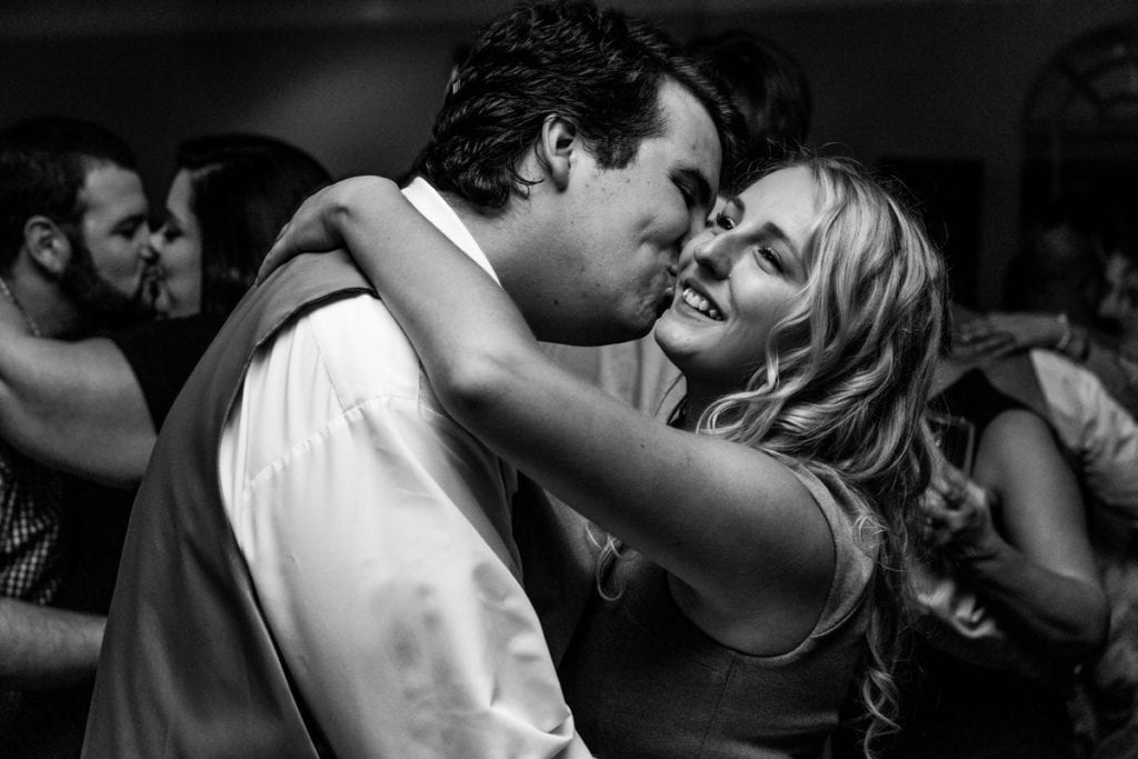 Man kisses woman's cheek during Cornwall evening wedding