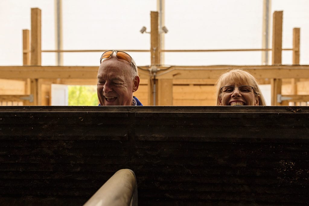 two adults looking over edge of horse trailer gate