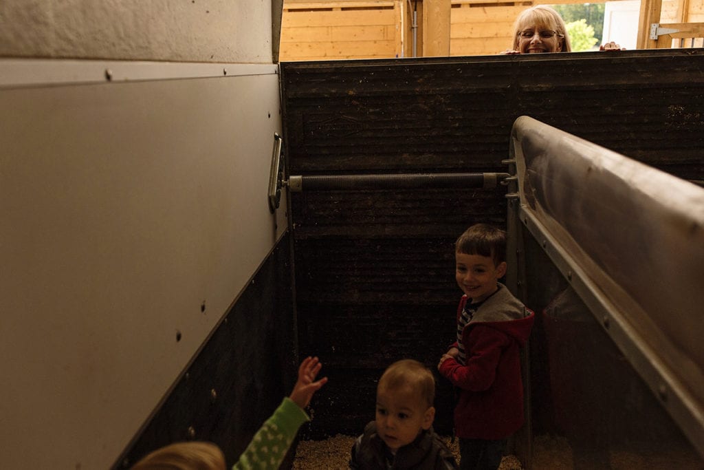 little girl pointing at grandma inside horse trailer