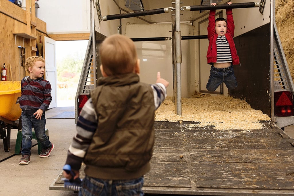 boys playing around horse trailer
