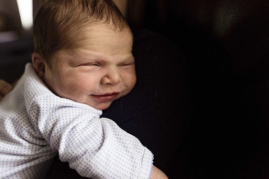 smiling baby resting on mom's shoulder