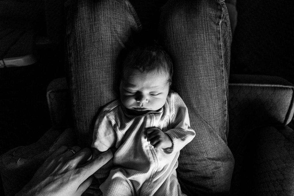 father holding newborn son in lap during session with Ottawa Family Photographer