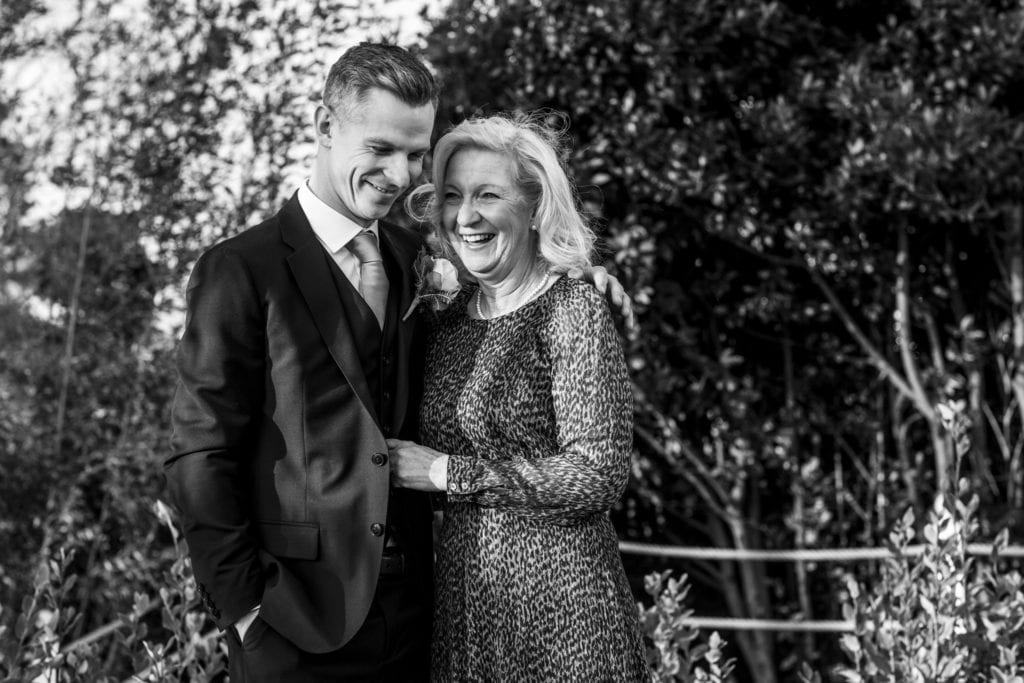 groom laughs with mother during groom prep at Christchurch Habour Hotel & Spa