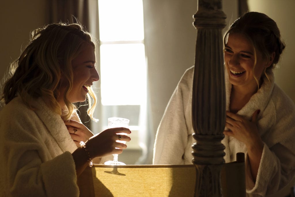 bridesmaids drink prosecco and laugh together during bridal prep at Christchurch Habour Hotel & Spa