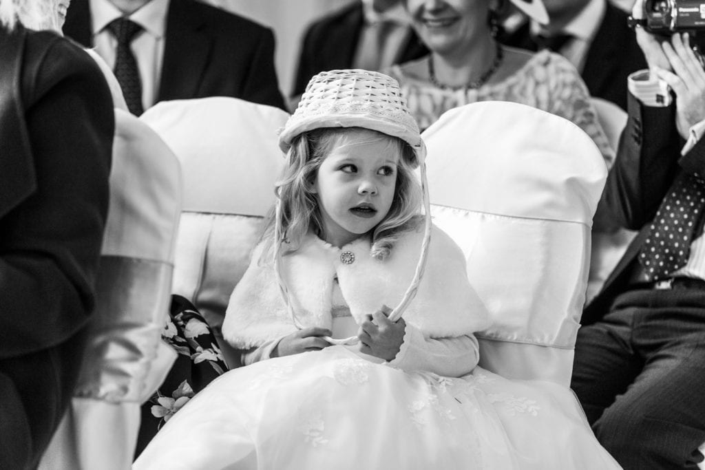 flower girls wears flower basket on her head during Highcliffe Castle wedding ceremony