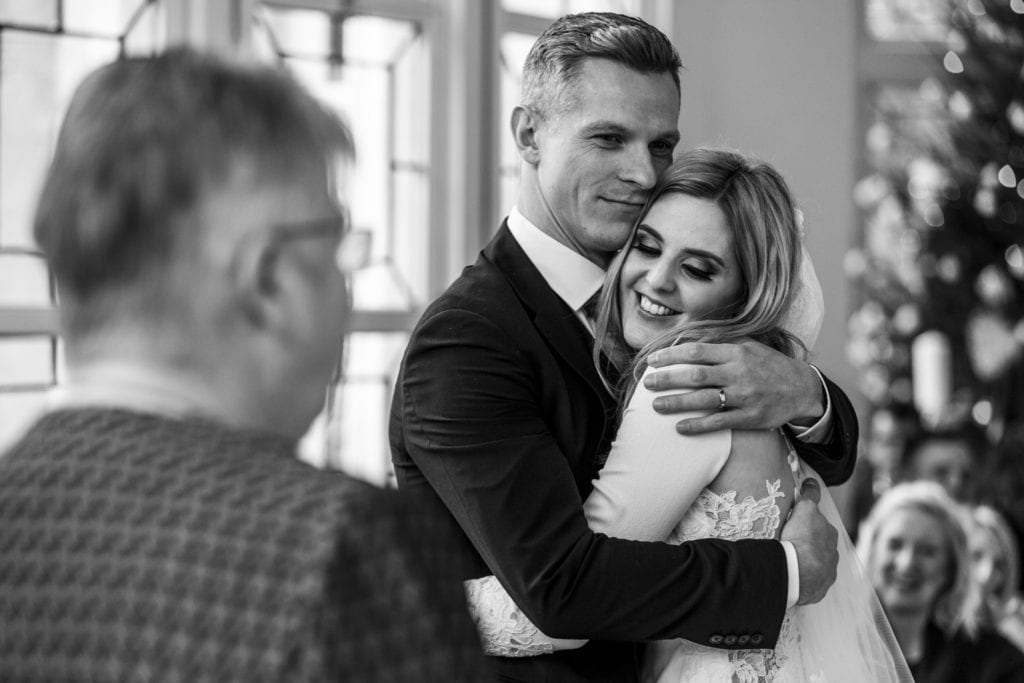 groom hugs bride after first kiss during chic New Forest wedding ceremony at Highcliffe Castle