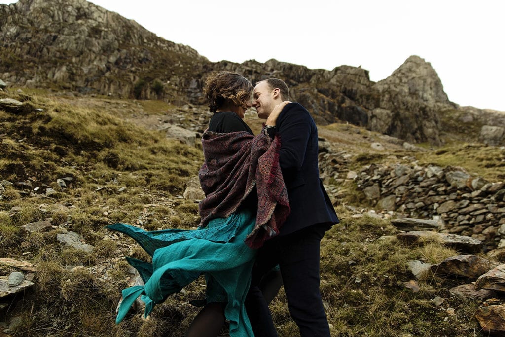 Couple cuddle on mountainside during Snowdonia portrait session