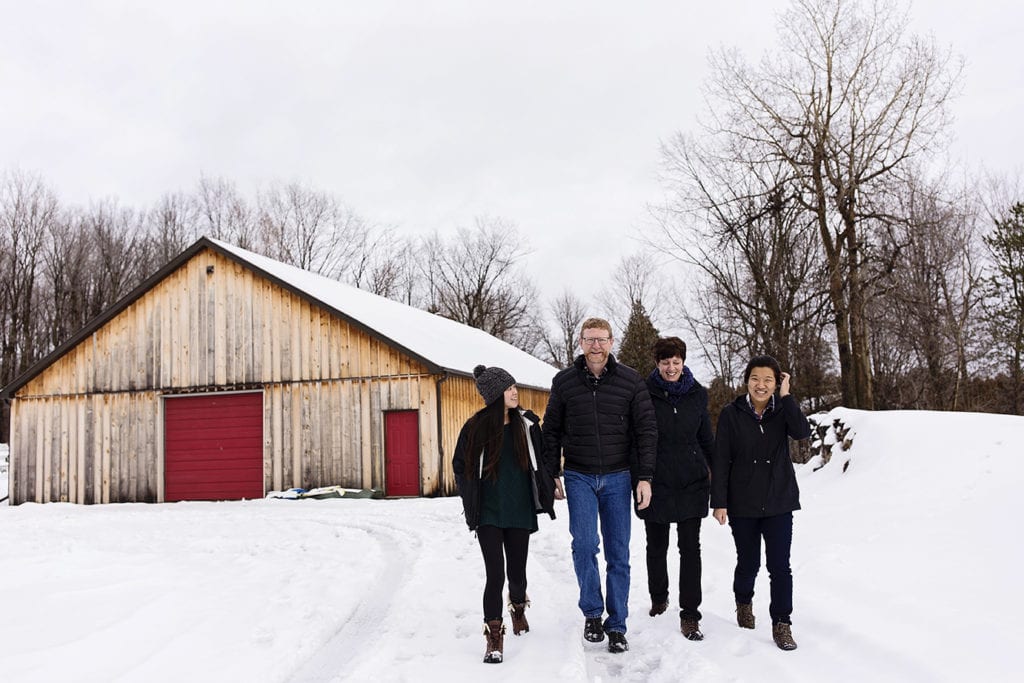 parents walk through the snow with two adopted daughters