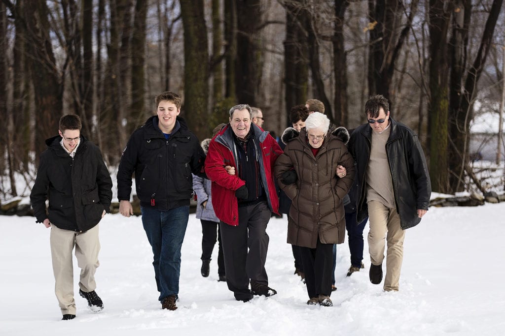 son and grandsons walk with grandparents in the snow
