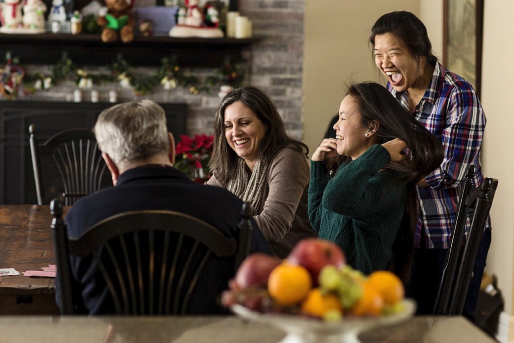 girls laughing at kitchen table during card game in Cornwall family photos