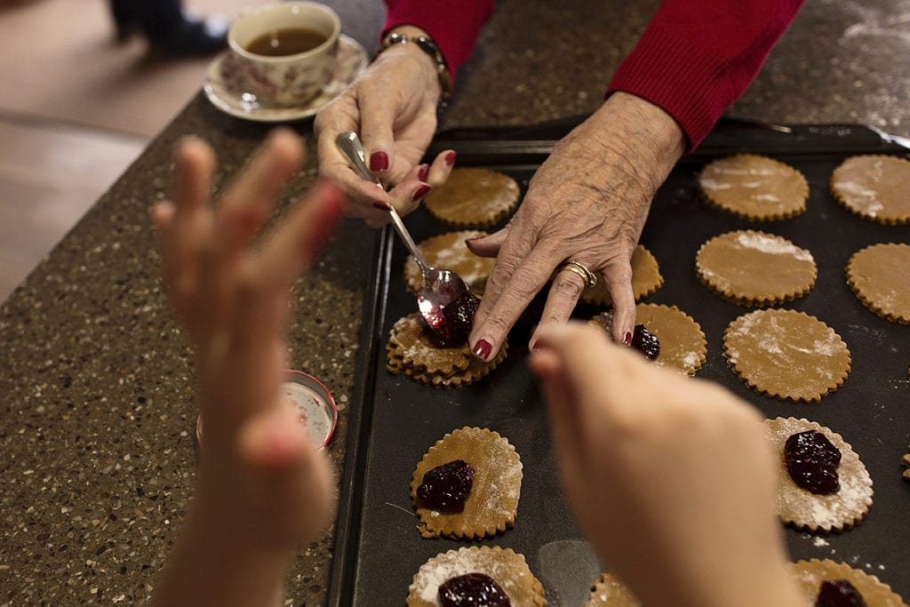 grandmother and granddaughter's hands while baking cookies
