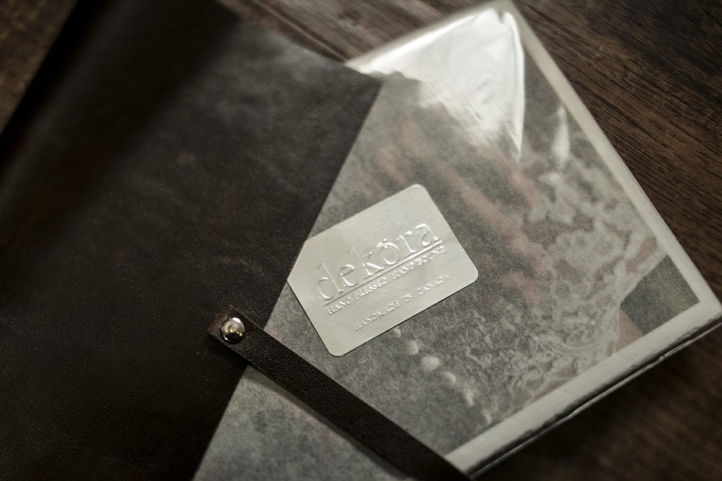 close up of Dekora Album Company packaging of modern Ontario wedding photos and dark leather photo satchel