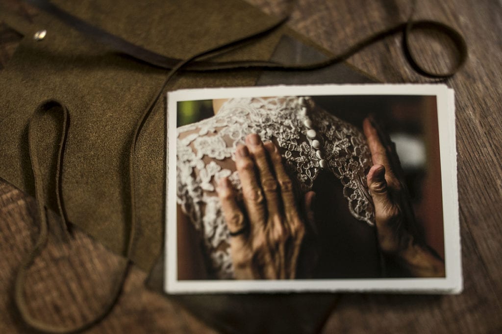 Modern Ontario wedding photos printed on fine art matte paper resting on top of dark leather satchel