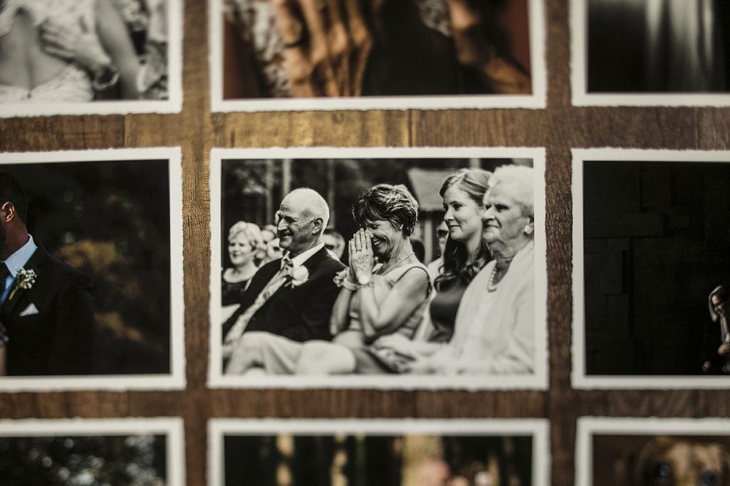 Hand torn matte printed modern wedding photos including mother of groom laughing while pressing hands to her face