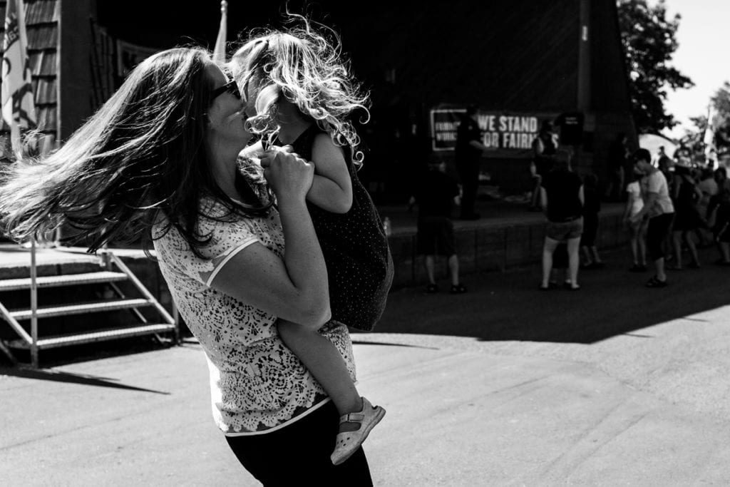 mother dances with daughter with hair flying during documentary session with ontario family photographer