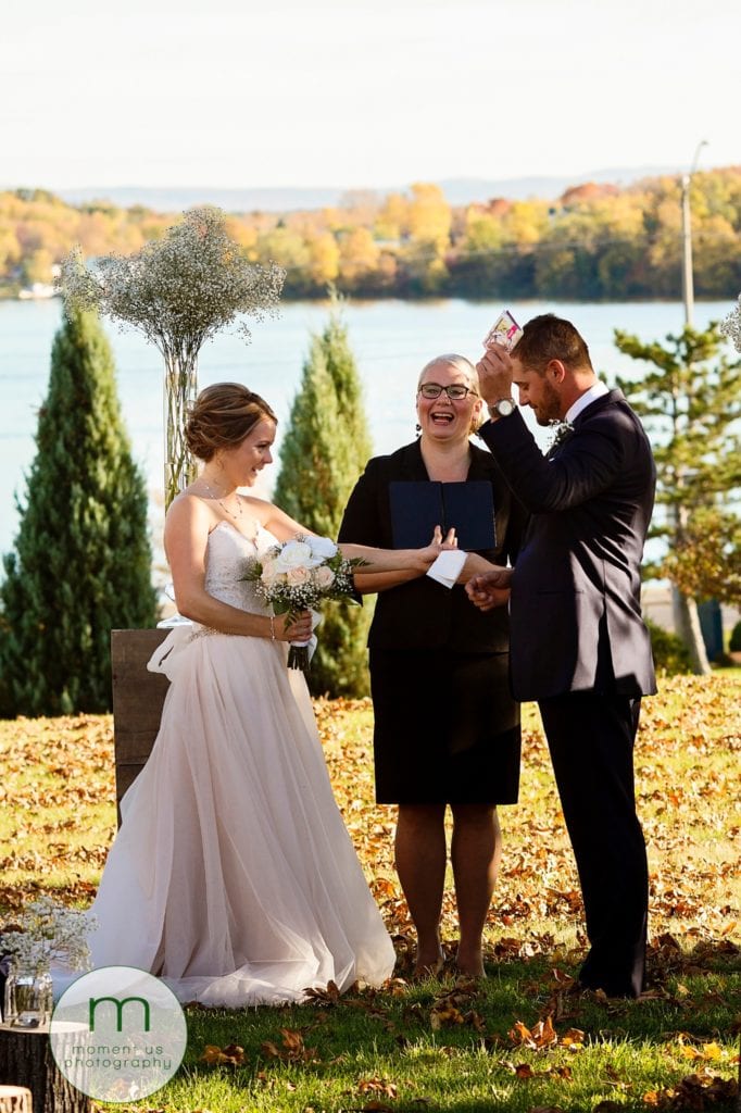 groom holds tissues in the air during wedding ceremony