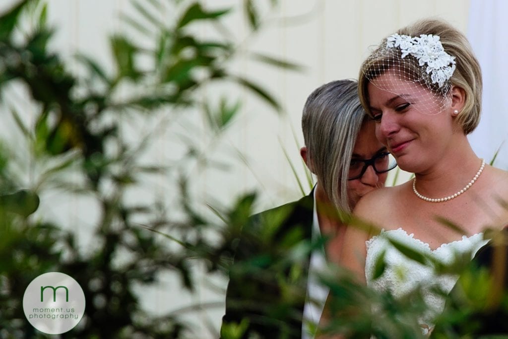 bride kisses wife's shoulder during lesbian wedding ceremony