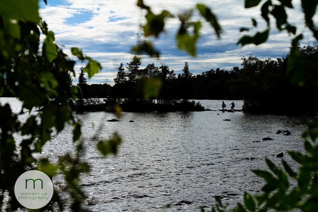 bride and groom walk on rocks into Lake Calabogie for Ontario & Quebec Wedding Photography portraits
