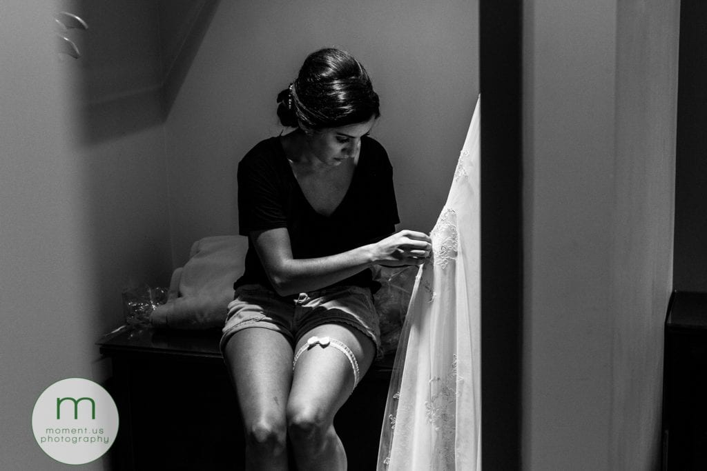 bride stitches gown before start of wedding reception