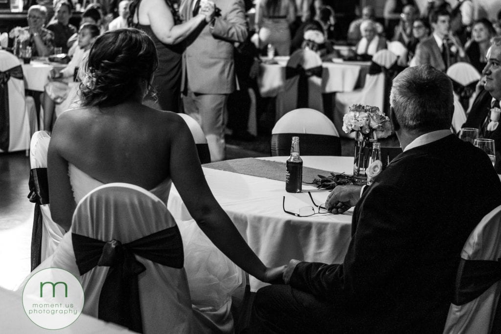 bride holds father's hand while groom dances with mother