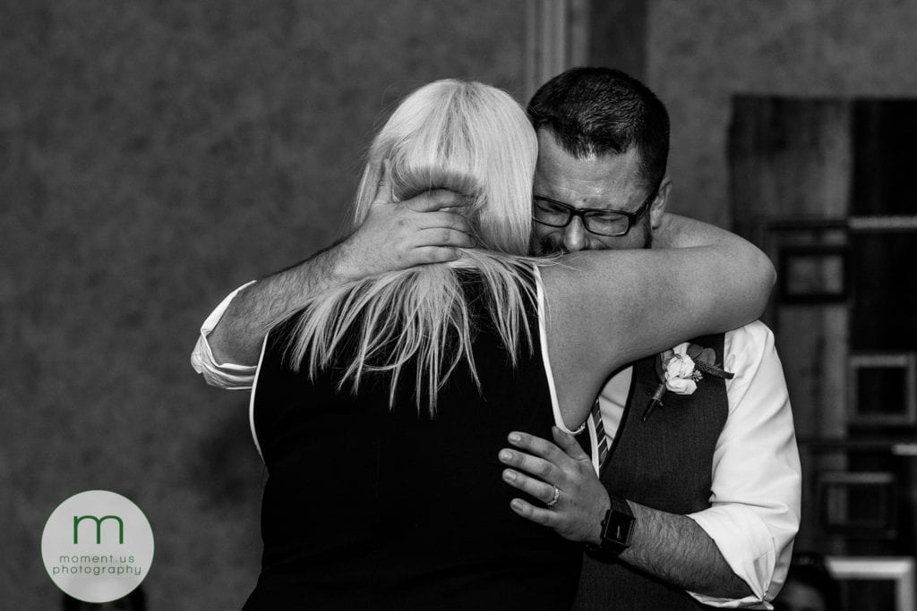crying groom hugs sister during first dance