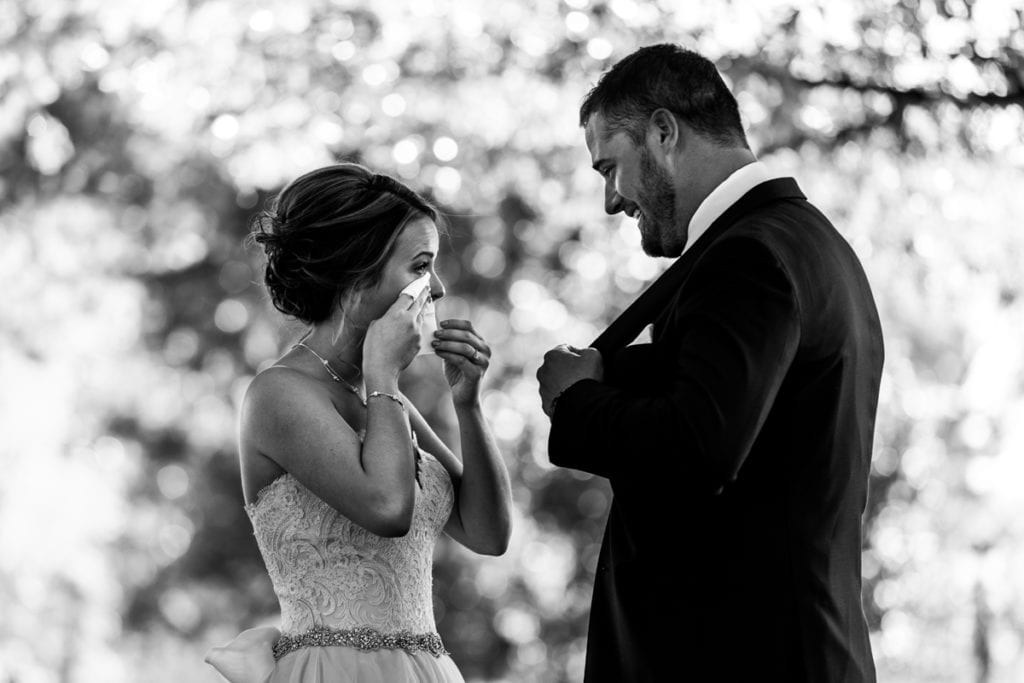 bride wipes tears during first look for Autumnal NAV Centre Cornwall Wedding