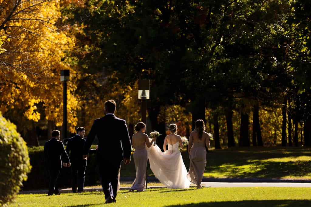 wedding party walking across lawn for Autumnal NAV Centre Cornwall Wedding